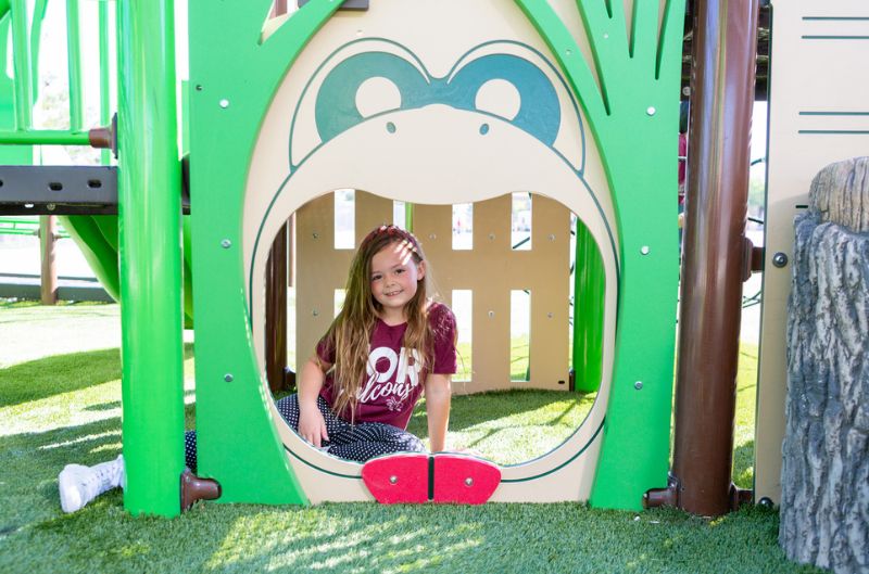 Baby girl sitting on play equipment