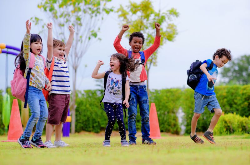 kids playing in playground with school bags